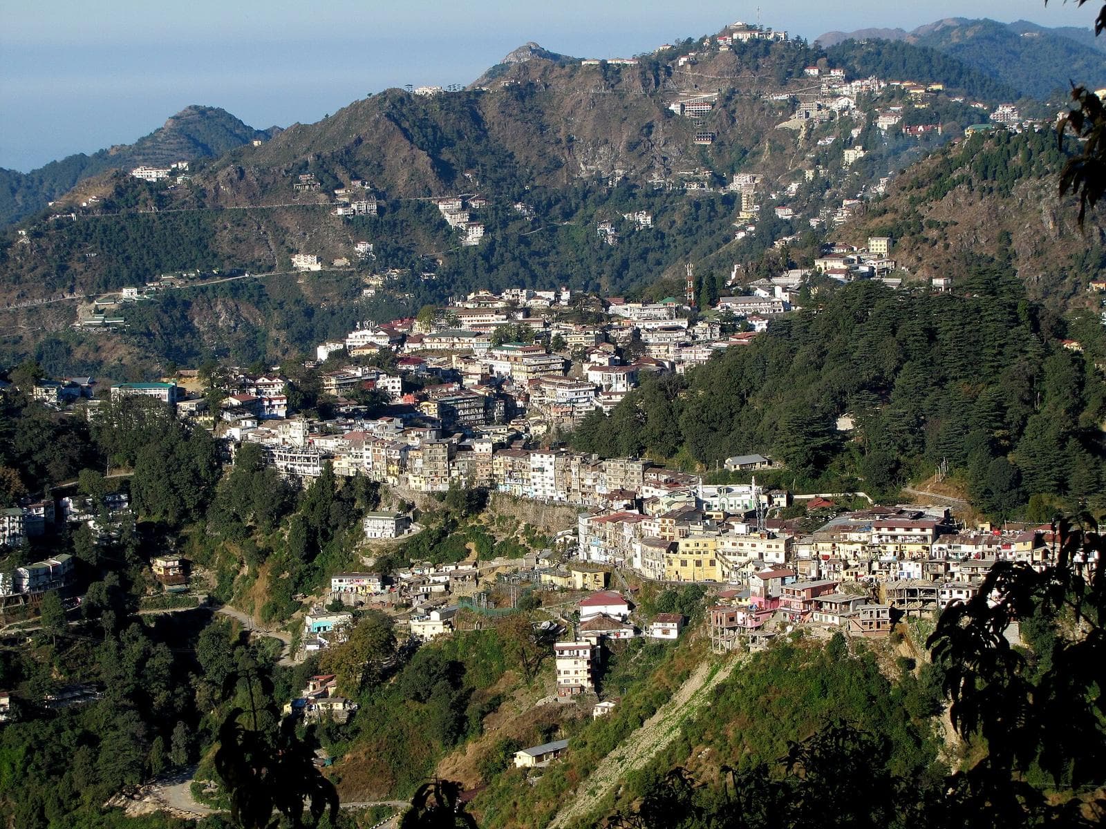 Mussoorie’s houses and hotels spread down a forested ridge, seen from Landour.